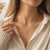 Woman wearing a Paw Print Initial Necklace in gold - her favorite pet Woman wearing a Paw Print Initial Necklace in gold