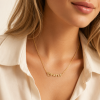 Woman wearing a personalized gold pet paw name necklace, meaningful mom gift