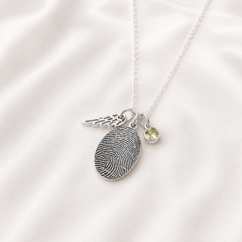 Personalized fingerprint pendant shown in silver with birthstone charm