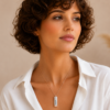 Woman wearing a hidden message necklace with a slim engraved capsule pendant by Keevola