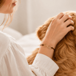 Gifts for pet lovers: woman hugging her golden retriever while wearing an engraved paw print name bracelet